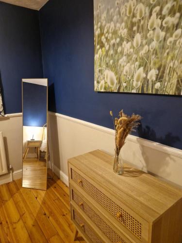 a vase on a table in a room with a painting at Markfield Maison in Markfield