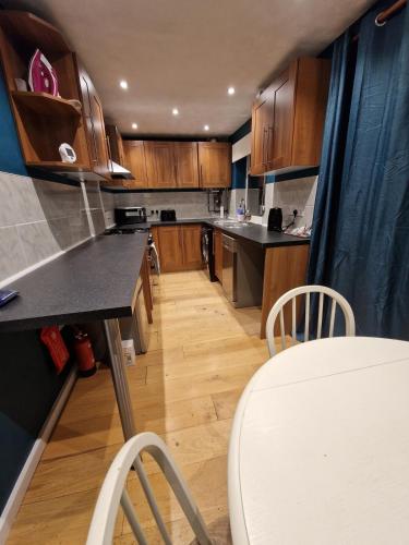 a kitchen with wooden cabinets and a table and chairs at Markfield Maison in Markfield
