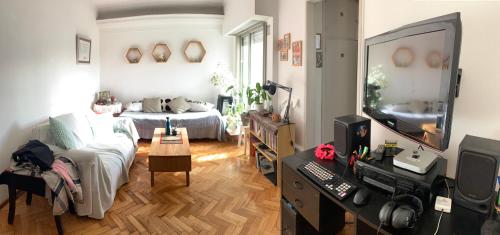 ein Wohnzimmer mit einem Bett und einem Schreibtisch mit einem Computer in der Unterkunft Cozy & Bright 2amb Belgrano Coghlan in Buenos Aires