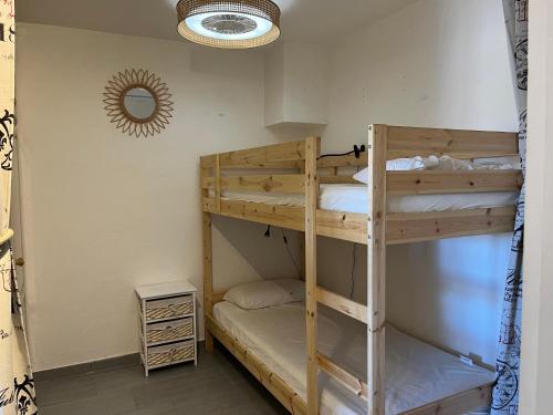 - 2 lits superposés dans une chambre avec un miroir dans l'établissement Appartement T2, 4 personnes, climatisé, avec piscine, Village de la Mer, à La Londe-les-Maures