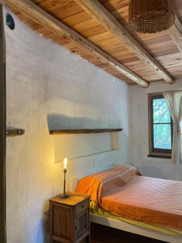 a bedroom with a bed and a candle on a table at Casa LaMora in San Marcos Sierras