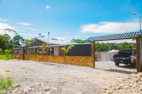 une maison avec une clôture et un camion devant dans l'établissement QUINTAPiedad, à Tena