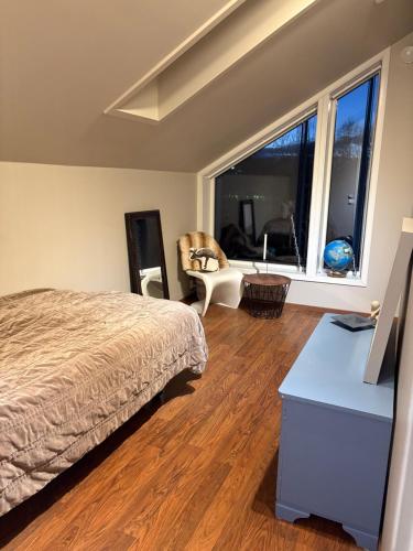 ein Schlafzimmer mit einem Bett und einem großen Fenster in der Unterkunft Modern & cozy house in Trondheim