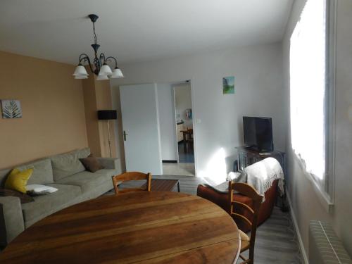 un salon avec une table en bois et un canapé dans l'établissement gîte MMR, à Saint-Saturnin
