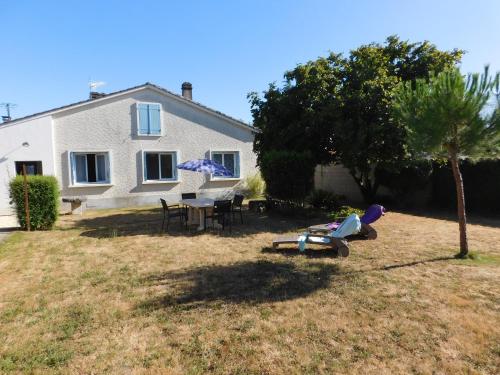 une maison avec une table et des chaises dans la cour dans l'établissement gîte MMR, à Saint-Saturnin