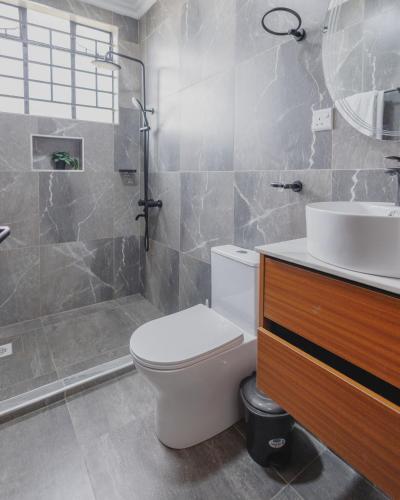 a bathroom with a toilet and a sink and a shower at Skyhut Boutique House Rooftop with LED-LIT DOME & Private Pool - Nairobi in Kitengela 