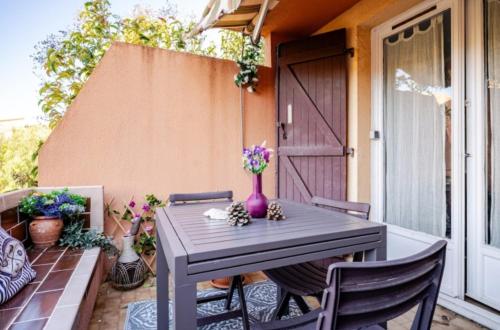 un vase violet sur une table sur une terrasse dans l'établissement Appartement 