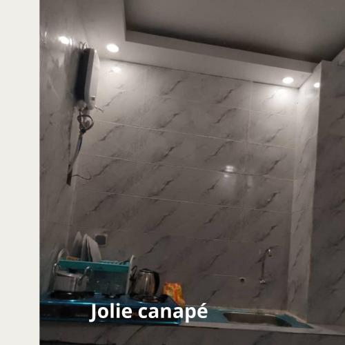 een badkamer met een marmeren muur en een wastafel bij Fôhundi home in Abidjan