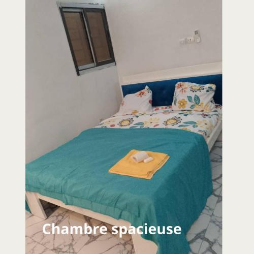 een slaapkamer met een bed met een handdoek erop bij Fôhundi home in Abidjan