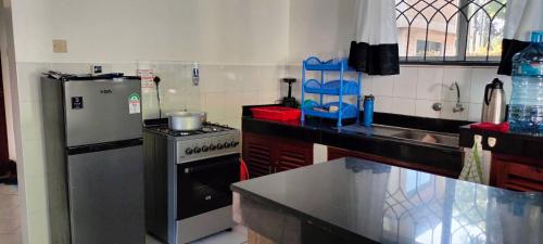 a kitchen with a refrigerator and a stove at Royal Palms Apartment A2 in Mtwapa