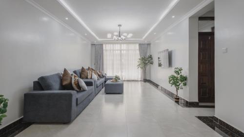 a living room with two blue couches in a room at Skyhut Boutique House Rooftop with LED-LIT DOME & Private Pool - Nairobi in Kitengela 