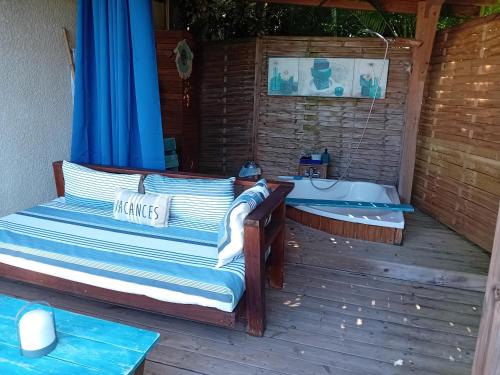 a bed and a bath tub on a deck at Ali-Naïs Location in Deshaies