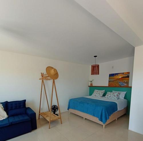 a bedroom with a bed and a blue couch at Maresia in Passo De Torres