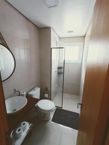 a bathroom with a toilet and a sink and a shower at Maresia in Passo De Torres