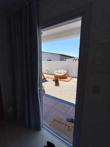a door to a room with a view of a patio at Maresia in Passo De Torres