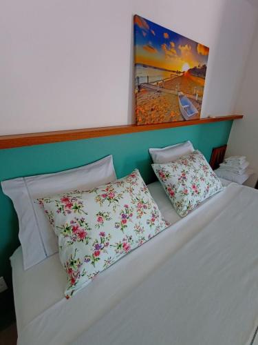 a bed with two pillows on top of it at Maresia in Passo De Torres