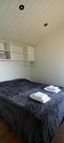 a room with a bed with two towels on it at Tinys Abedul in Villa Meliquina