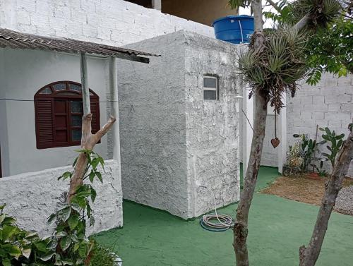 a house with a green yard with a building at Kitnet Inteira São P da Aldeia in São Pedro da Aldeia