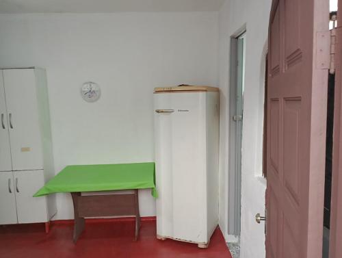 a green bench next to a refrigerator in a room at Kitnet Inteira São P da Aldeia in São Pedro da Aldeia