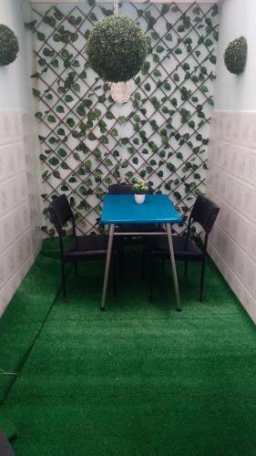 a table with chairs and a green floor at appartement central plein d’expérience in Martil