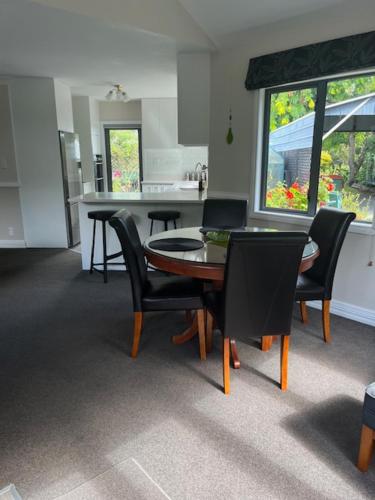 a kitchen and dining room with a table and chairs at Emerald Haven in Upper Hutt