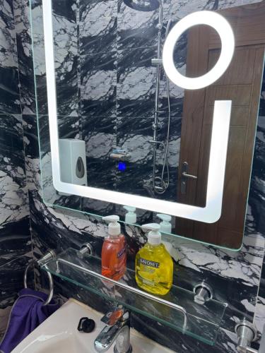 a mirror above a sink in a bathroom at logement luxueuse au pieds du monument de la renaissance africaine in Dakar