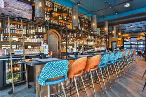 a bar with a row of chairs in a restaurant at Hotel Indigo - Silverthorne by IHG in Silverthorne