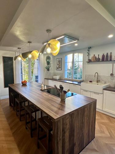 une cuisine avec un grand îlot en bois au milieu dans l'établissement Villa Mimpi - Castres, France, à Castres