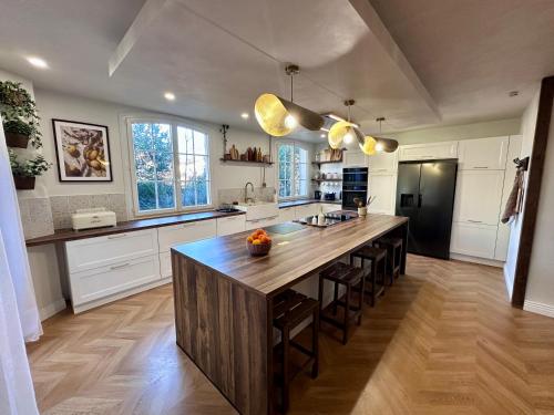 une cuisine avec un grand îlot en bois au milieu dans l'établissement Villa Mimpi - Castres, France, à Castres