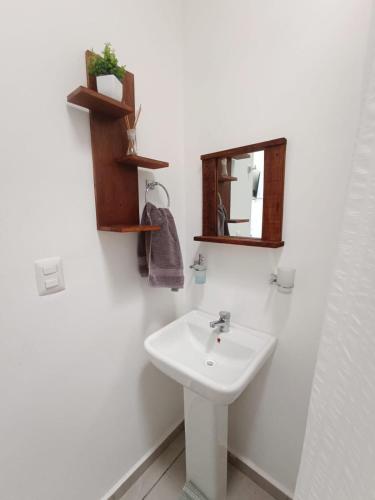 a white bathroom with a sink and a mirror at Casa Kulkana 194 in Cancún