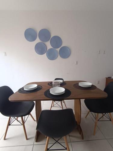 a wooden table with chairs and plates on it at Casa Kulkana 194 in Cancún