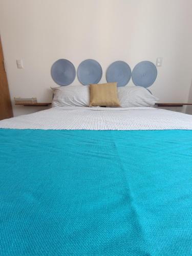 a bed with a blue blanket on top of it at Casa Kulkana 194 in Cancún