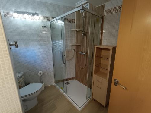 a bathroom with a toilet and a glass shower at AP Over the Sea in Arenales del Sol