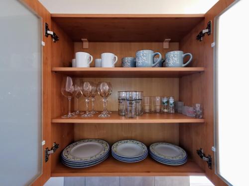 a pantry with plates and glasses on shelves at Novozrekonstruovany apartman pri boroviciach in Štrbské Pleso