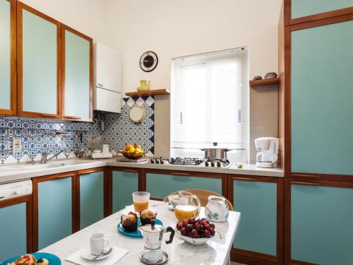 a kitchen with a table with a bowl of fruit on it at San Domenico Apartment in Taormina