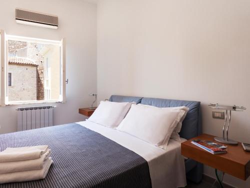 a bedroom with a bed with a table and a window at San Domenico Apartment in Taormina