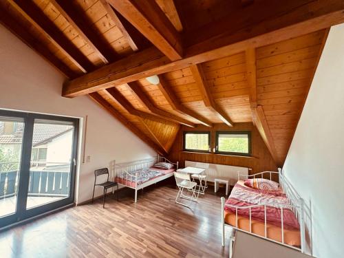 マールベルクにあるHaus in Mahlberg - Erd- und Dachgeschossのベッド2台とテーブルと椅子のある部屋