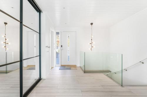 a hallway with glass doors and a staircase at Casa Knott 4 Bedroom in Ulstein