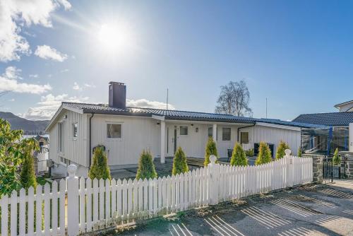 a white picket fence in front of a white house at Casa Knott 4 Bedroom in Ulstein