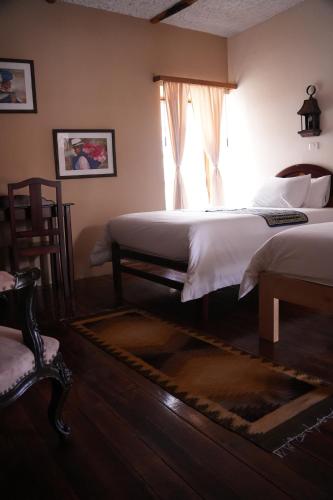 a bedroom with a bed and a window and a rug at Land of the Sun Hotel & Spa in Cotacachi