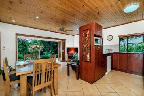 a kitchen and dining room with a wooden ceiling at Secluded Romantic Getaway For Two - Kuranda Queensland in Kuranda