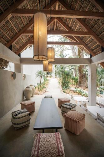 a large room with a table and benches and a ceiling at Esh Hotel & Spa in Nosara
