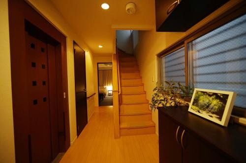 a hallway of a house with a staircase and a window at 木漏の宿 in Osaka