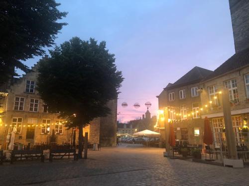 a city street at night with buildings and lights at Huyze Vinck in Veurne