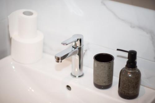 a bathroom sink with a faucet and a bottle of soap at Royal Premium by Vucko Jahorina Serviced Apartments in Jahorina