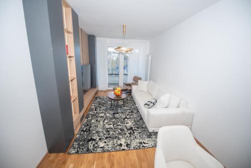 a living room with a white couch and a rug at Royal Premium by Vucko Jahorina Serviced Apartments in Jahorina