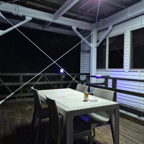 a table and chairs on a porch at night at 대마도쇼핑구마에하우스 in Tsushima