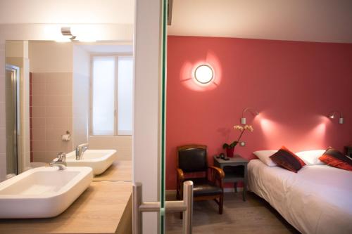 een badkamer met een bed, een bad en een wastafel bij Hotel Restaurant Le Sully in Saint-Saud-Lacoussière
