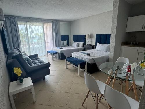 a living room with a couch and a bed and a table at Hermoso Depto con vista al mar en zona hotelera. in Cancún