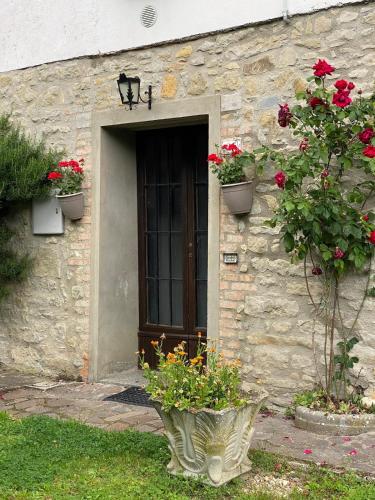 a stone building with a door with flowers in front of it at Casa Angiolino, angolo di pace vicino all'Orrido di Gea in Villa dʼAiano